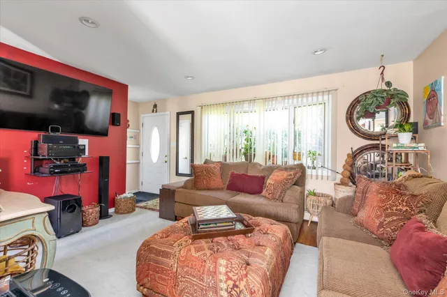 a living room with furniture a flat screen tv and a window
