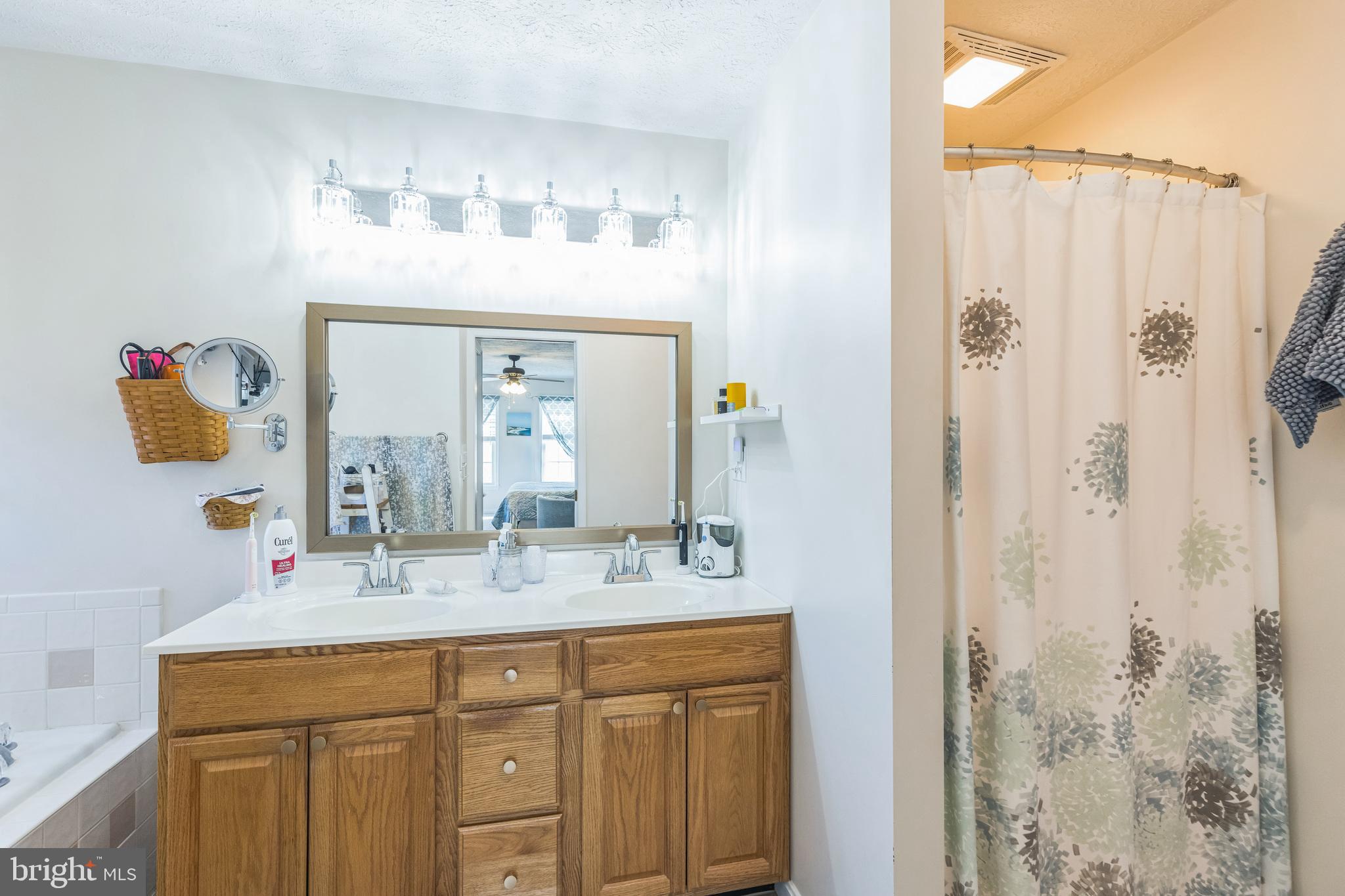 2734 Old Fort Schoolhouse Road Westminster, MD 21157 - Photo 42 of 44 a bathroom with a granite countertop sink a mirror and a shower