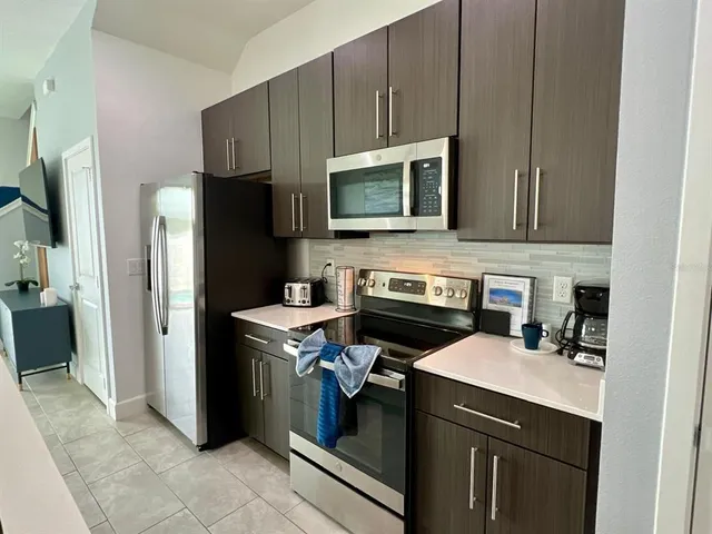a kitchen with stainless steel appliances a stove microwave and refrigerator