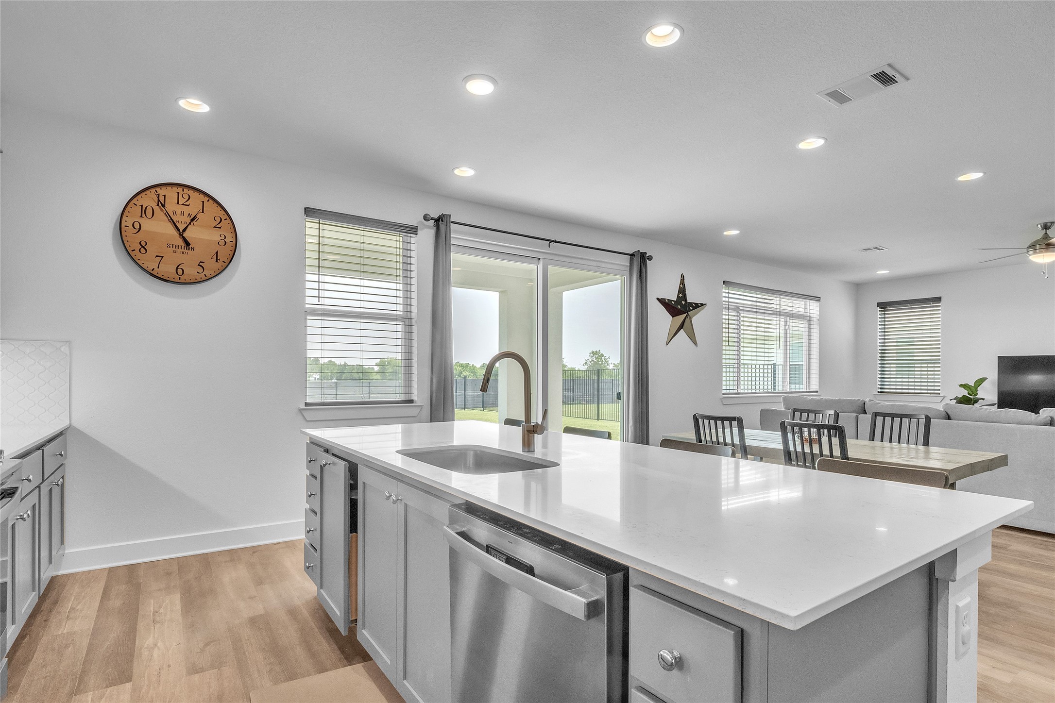 3706 Mesquite Vly Road Georgetown, TX 78628 - Photo 9 of 30 Kitchen with stainless steel dishwasher, a sink, a center island with sink, recessed lighting, and light wood-style flooring