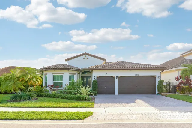 a front view of a house with a yard and potted plants