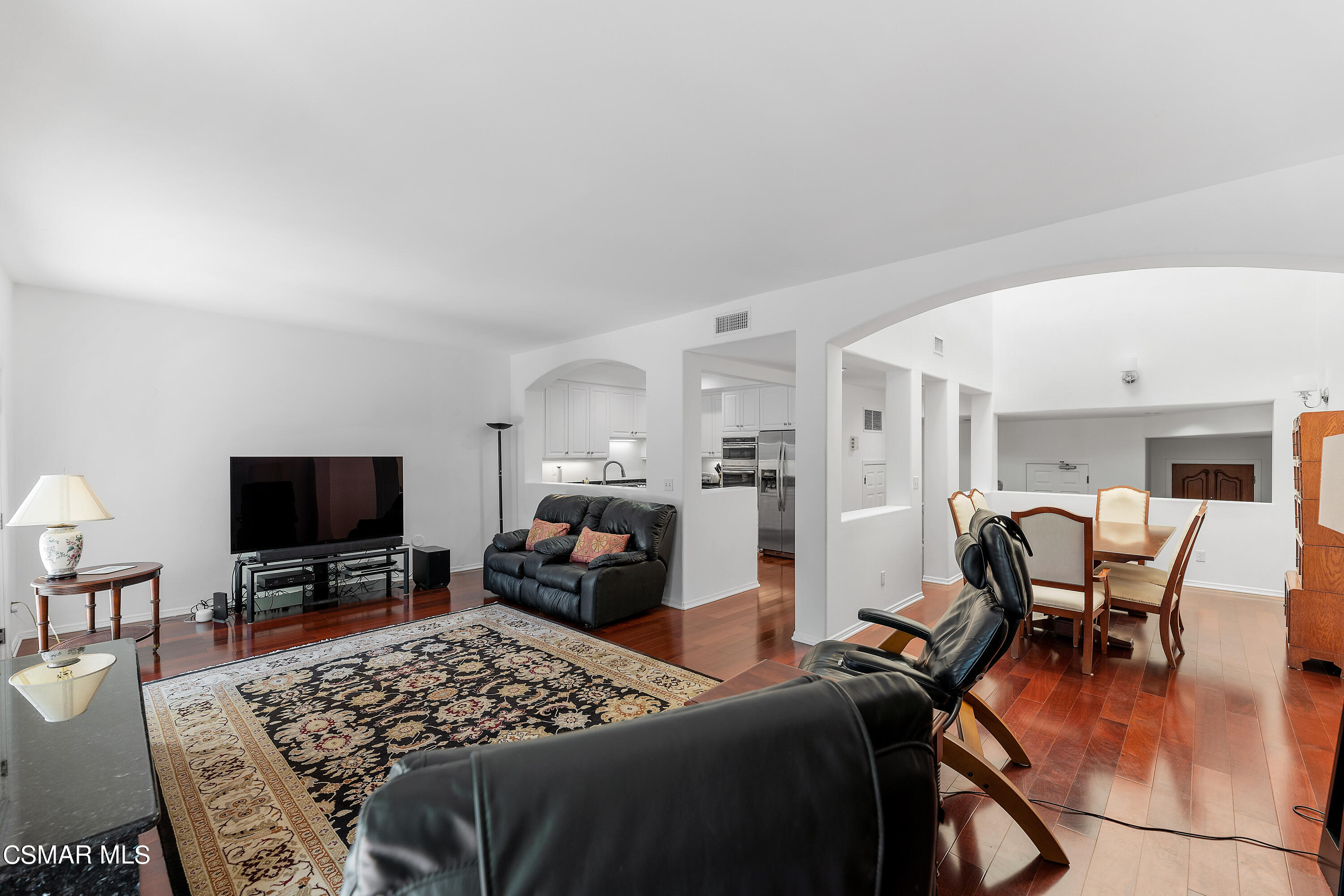 6435 Zumirez Drive, Unit 15 Malibu, CA 90265 - Photo 13 of 38 a living room with furniture a flat screen tv and kitchen view