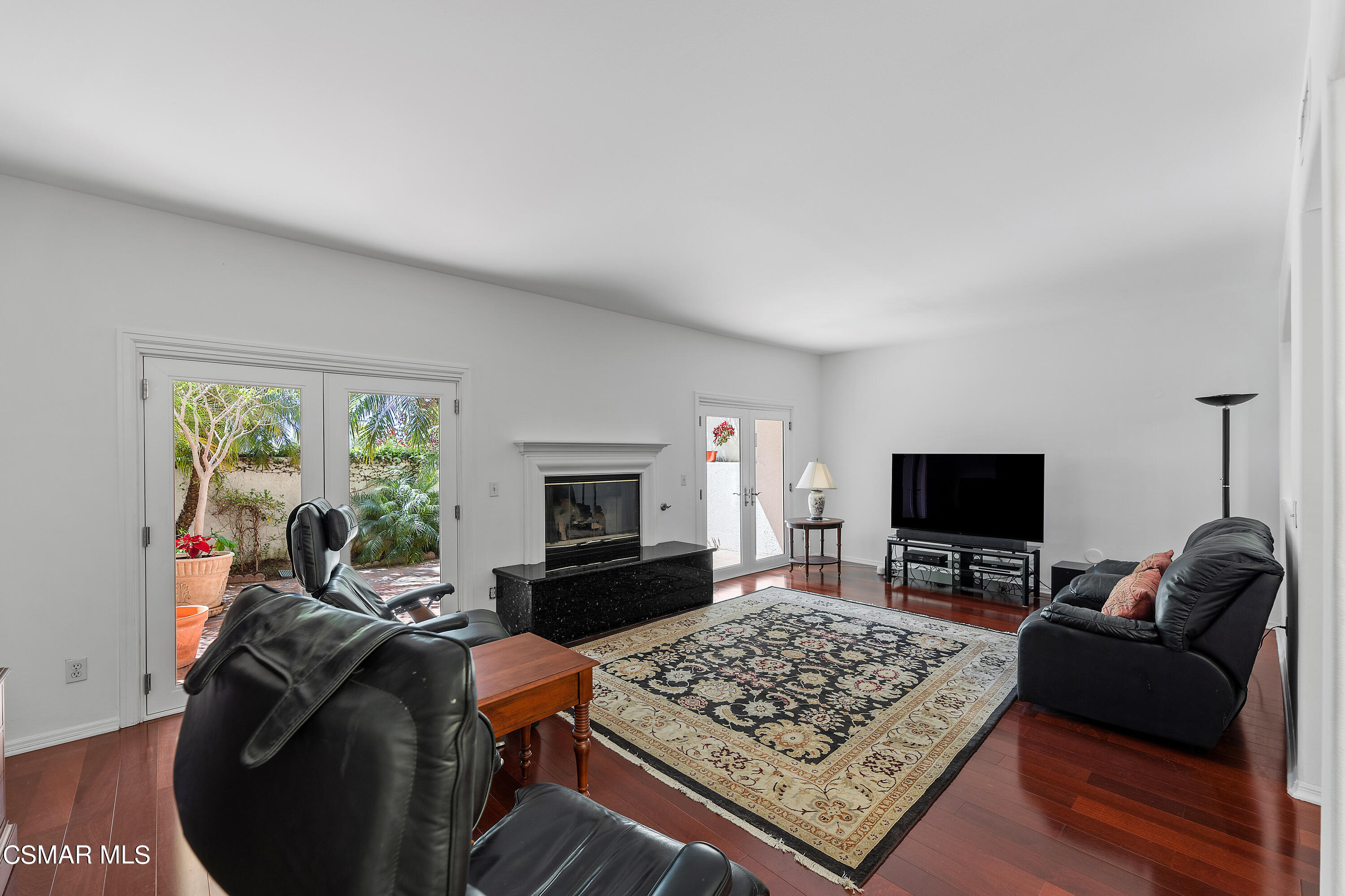 6435 Zumirez Drive, Unit 15 Malibu, CA 90265 - Photo 9 of 38 a living room with furniture a rug and a fireplace