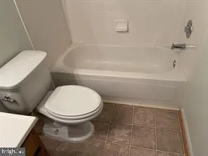 a white toilet sitting next to a bath tub