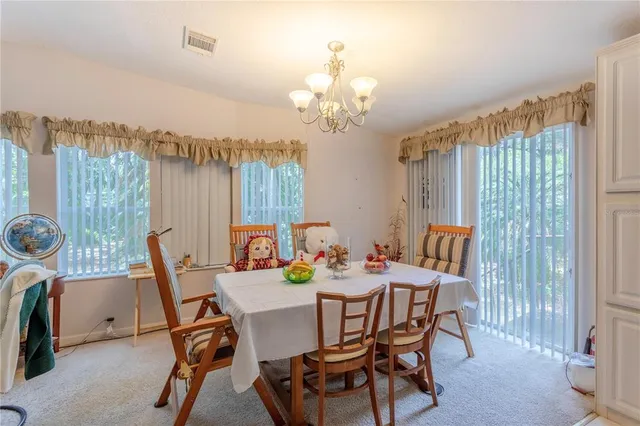 a dining room with furniture a chandelier and a rug