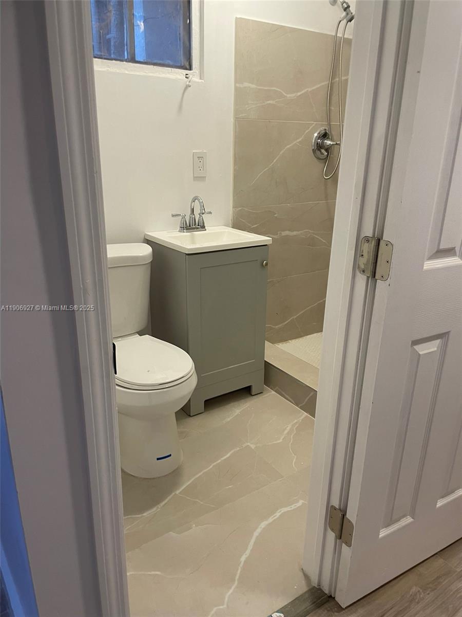 746 Northeast 80th Street, Unit GAR Miami, FL 33138 - Photo 13 of 14 a bathroom with a sink a toilet and shower