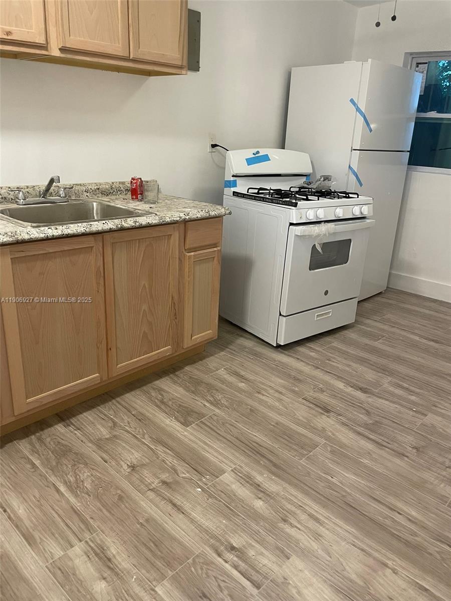 746 Northeast 80th Street, Unit GAR Miami, FL 33138 - Photo 7 of 14 a kitchen with granite countertop a stove and a sink