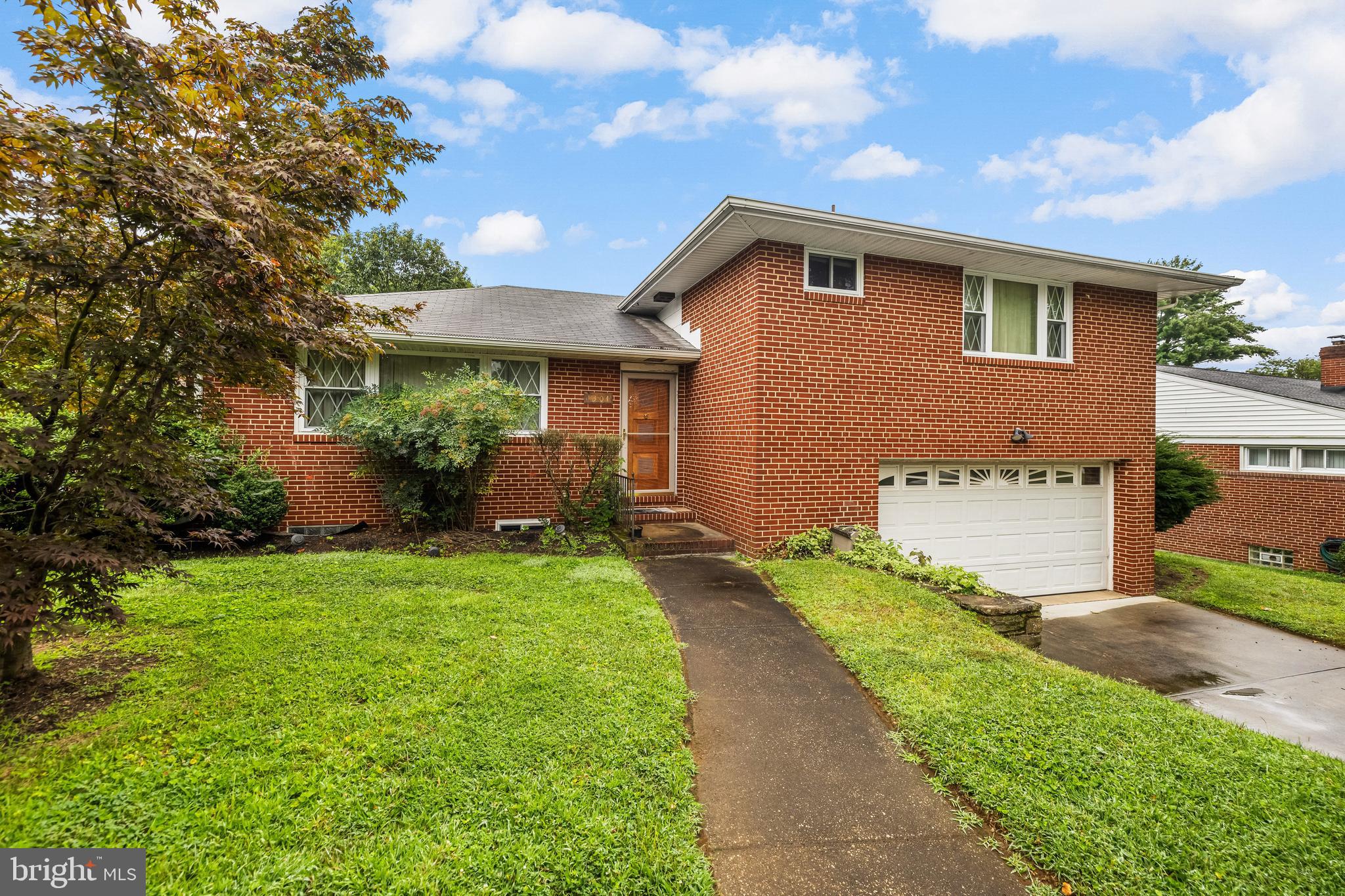 1304 Heather Hill Road Baltimore, MD 21239 - Photo 2 of 40 a front view of a house with a yard and potted plants
