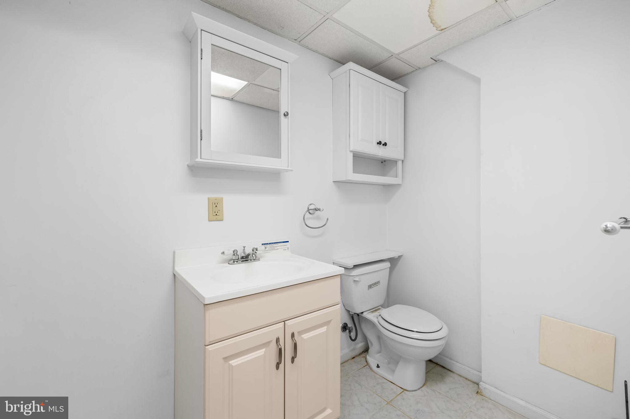 1304 Heather Hill Road Baltimore, MD 21239 - Photo 34 of 40 a bathroom with a toilet sink vanity and mirror