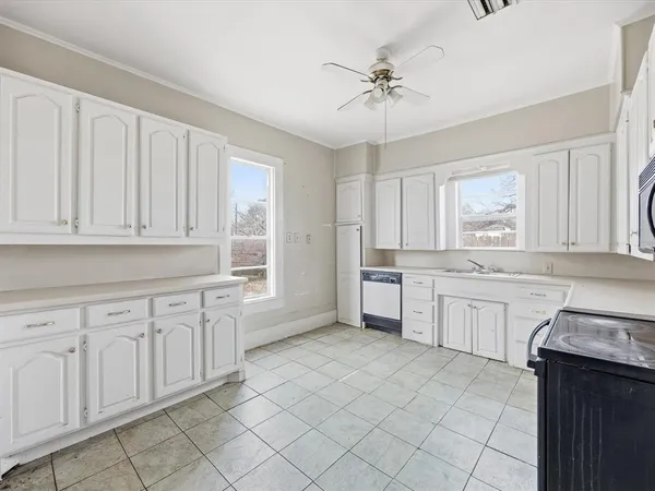 a kitchen with granite countertop white cabinets white stainless steel appliances with a sink and dishwasher