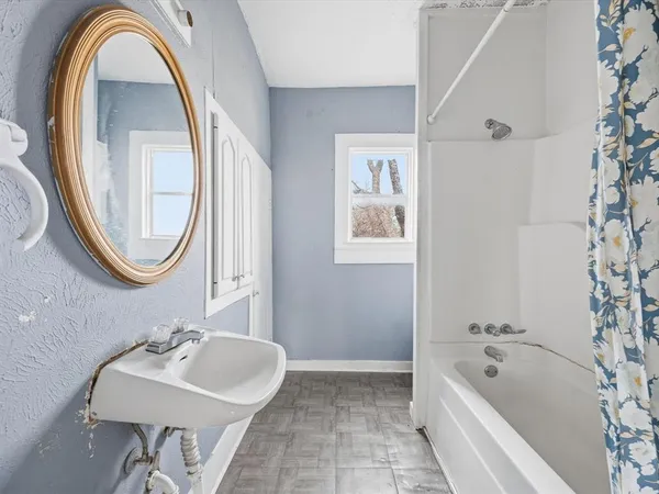 a bathroom with a sink a bathtub and a mirror
