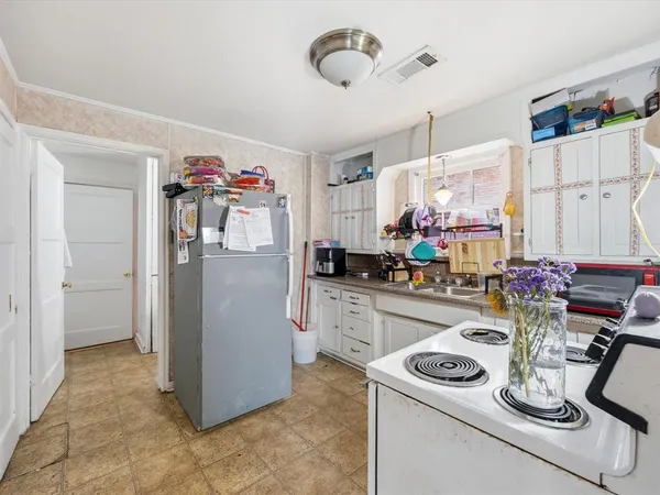 a kitchen with a refrigerator and a stove top oven