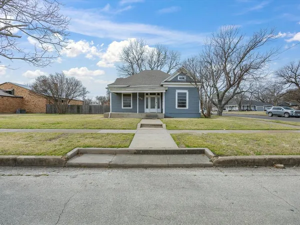 a view of a house with a big yard and large trees