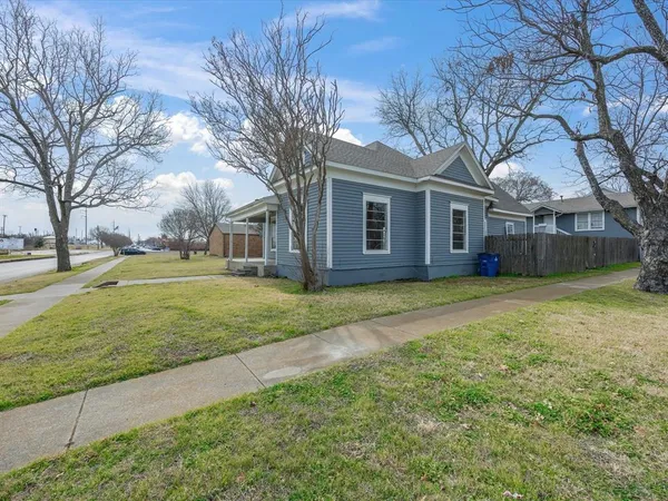 a view of a house with a yard and large trees