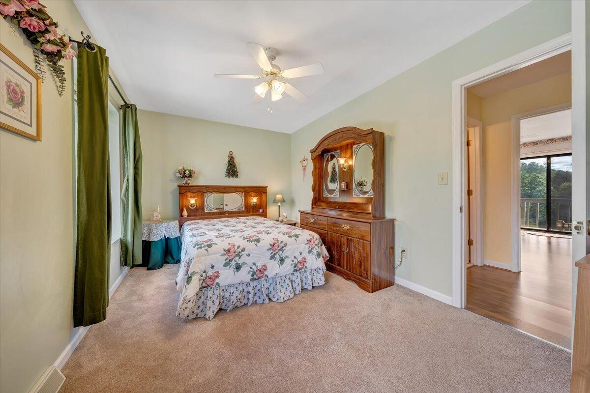301 Harbor Ridge Drive Goodview, VA 24095 - Photo 14 of 56 a bedroom with a bed and a chandelier