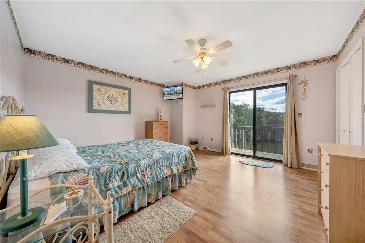 301 Harbor Ridge Drive Goodview, VA 24095 - Photo 16 of 56 a bedroom with a large bed and a chandelier