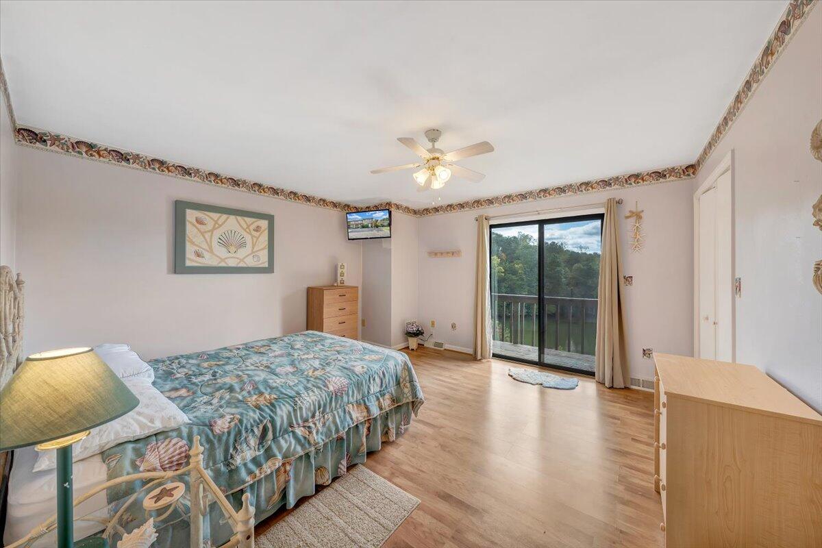 301 Harbor Ridge Drive Goodview, VA 24095 - Photo 17 of 56 a bedroom with a large bed and a chandelier