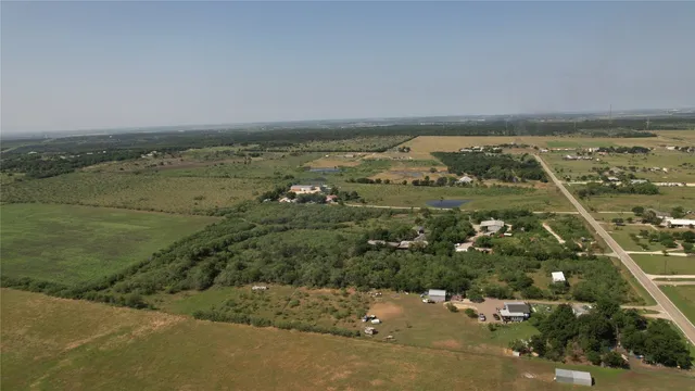 an aerial view of ocean and residential houses with outdoor space