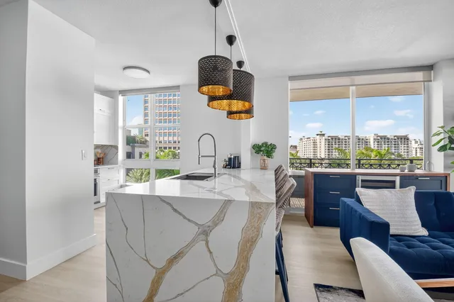 a living room with furniture kitchen view and a chandelier