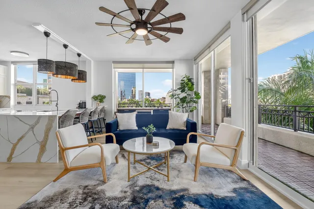 a living room with furniture a chandelier and a window