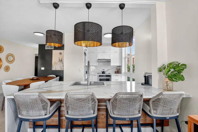 a kitchen with stainless steel appliances granite countertop a sink a stove and a wooden floor