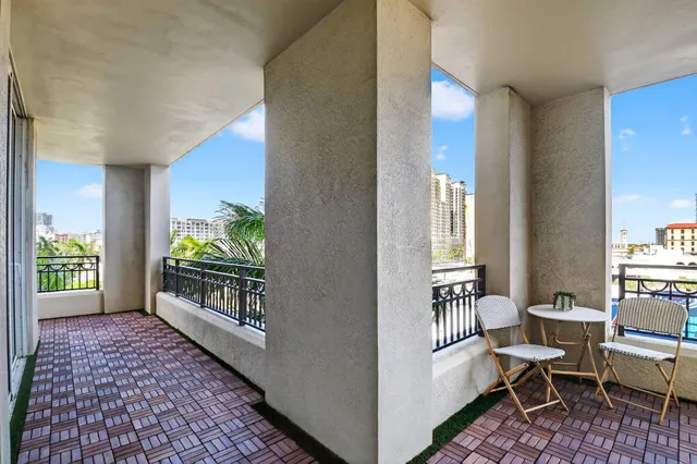 a front view of a building with garden and trees