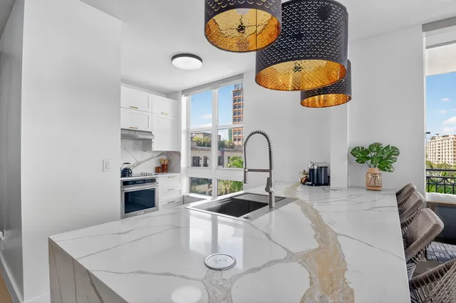 a kitchen with stainless steel appliances white cabinets and a window