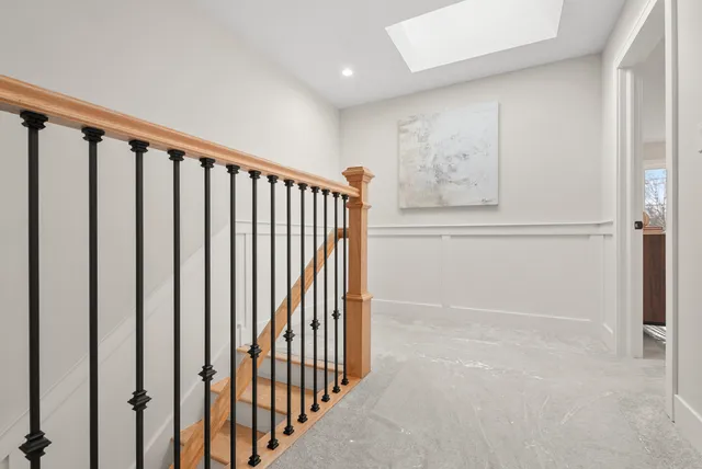 a view of staircase with railing and white walls