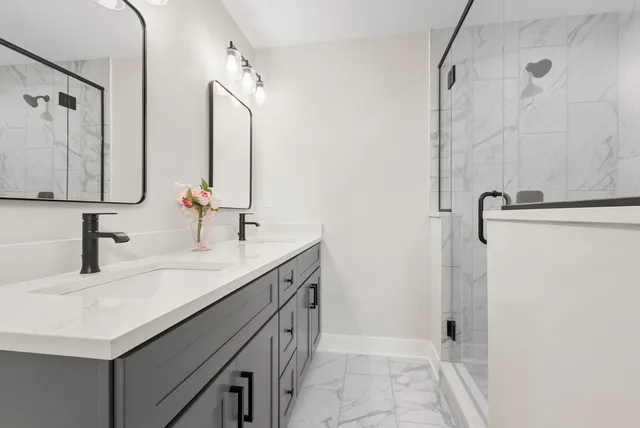 a bathroom with a double vanity sink a mirror and shower