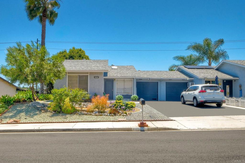 a front view of a house with a garden and mountain view