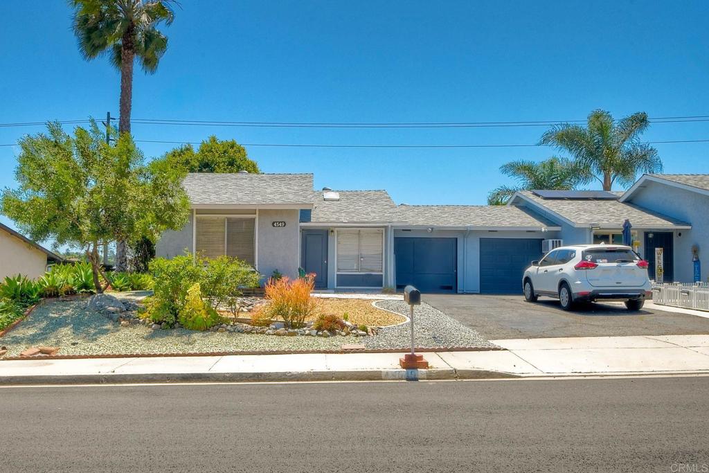 4549 Quailridge Drive Oceanside, CA 92056 - Photo 2 of 25 a front view of a house with a garden and parking space
