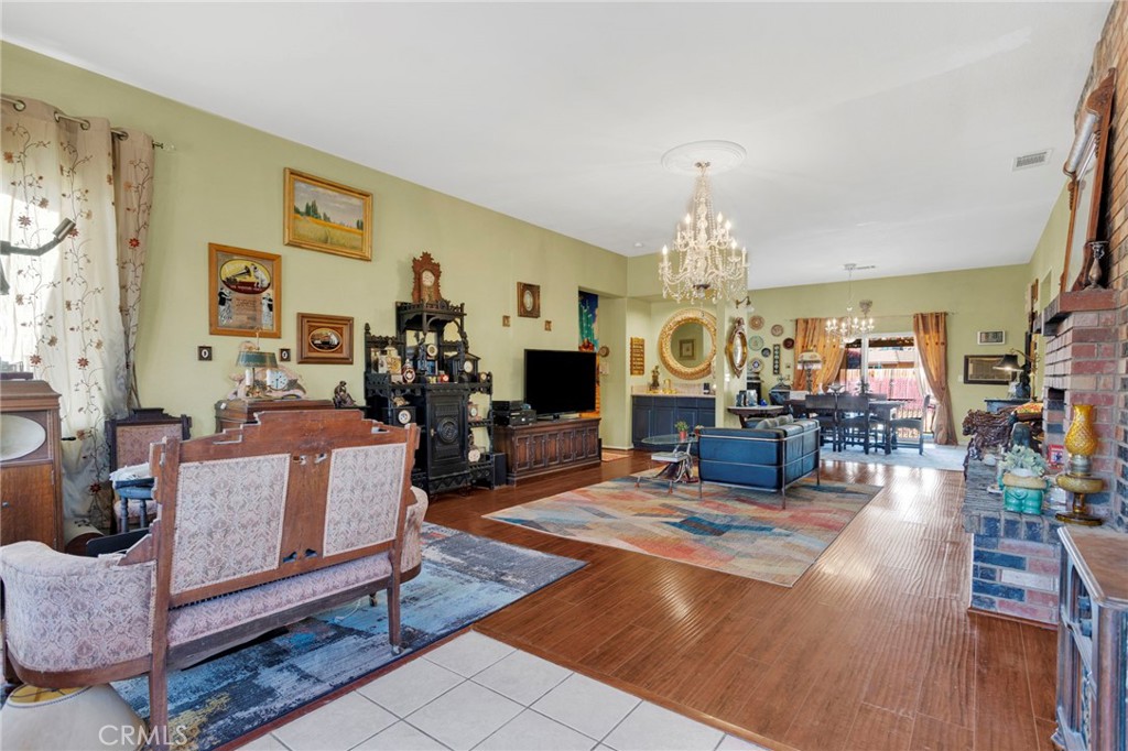 20151 Serrano Road Apple Valley, CA 92307 - Photo 11 of 59 a living room with furniture a chandelier and a fireplace