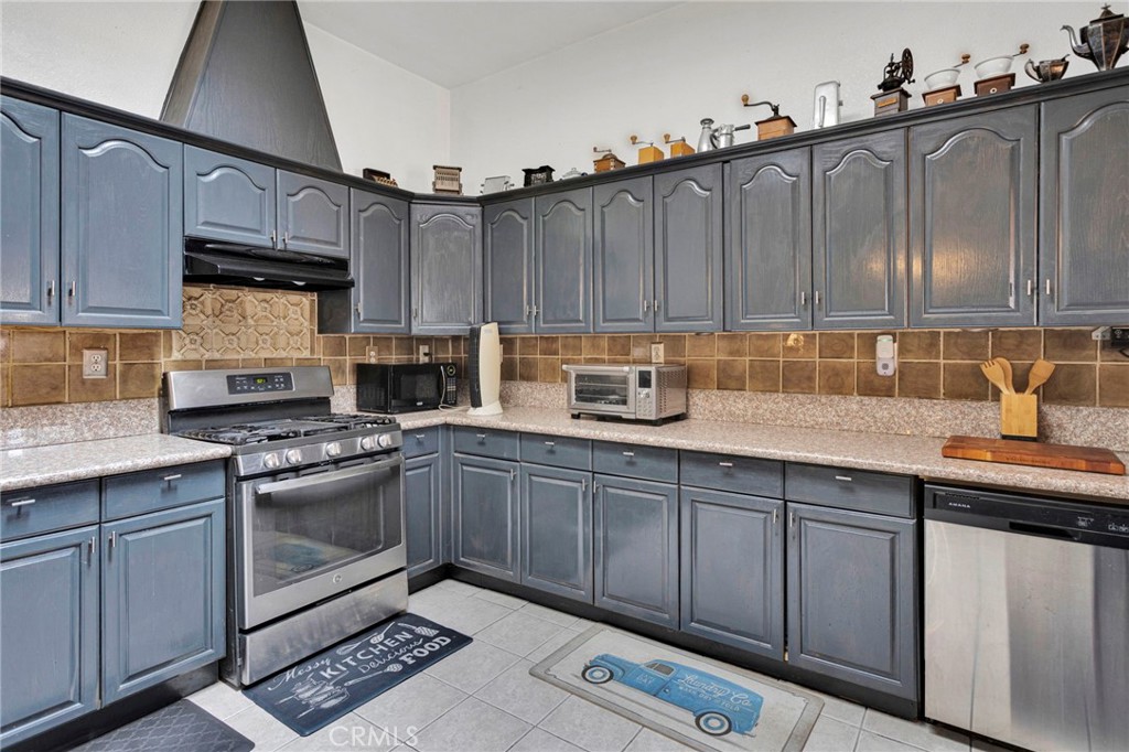 20151 Serrano Road Apple Valley, CA 92307 - Photo 18 of 59 a kitchen with granite countertop a sink a stove and cabinets