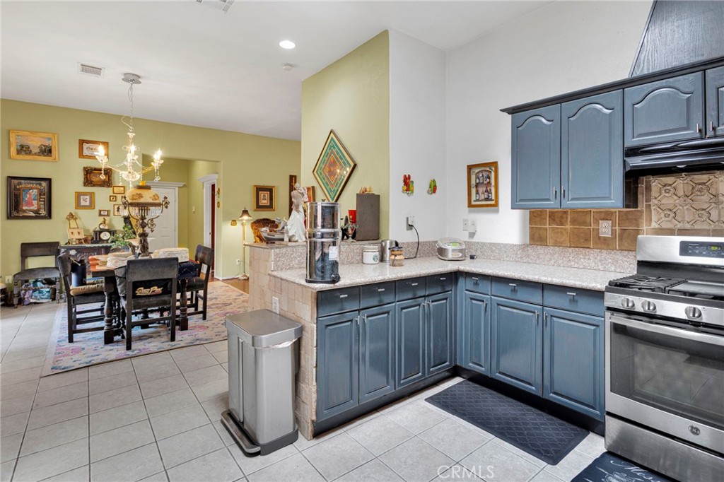 20151 Serrano Road Apple Valley, CA 92307 - Photo 19 of 59 a kitchen with stainless steel appliances granite countertop a stove a sink dishwasher and cabinets