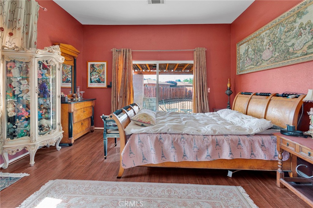 20151 Serrano Road Apple Valley, CA 92307 - Photo 25 of 59 a bedroom with a bed and wooden floor