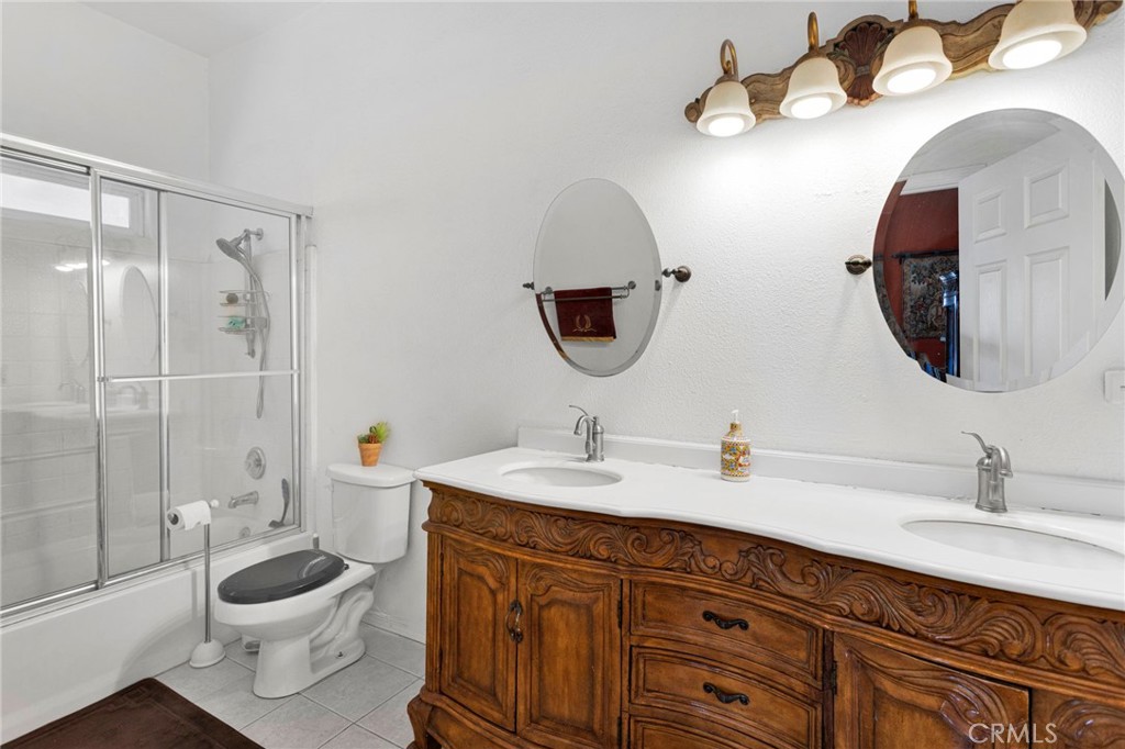 20151 Serrano Road Apple Valley, CA 92307 - Photo 27 of 59 a bathroom with a toilet a sink and mirror