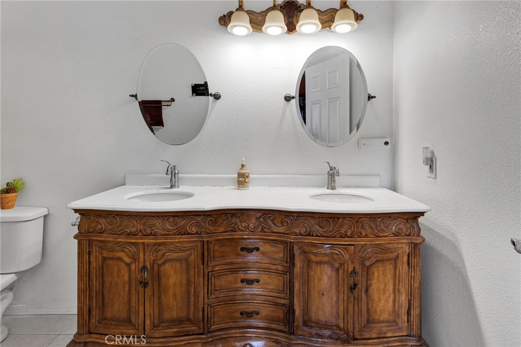 20151 Serrano Road Apple Valley, CA 92307 - Photo 28 of 59 a sink with a mirror and vanity