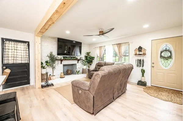 a living room with furniture a fireplace and a flat screen tv
