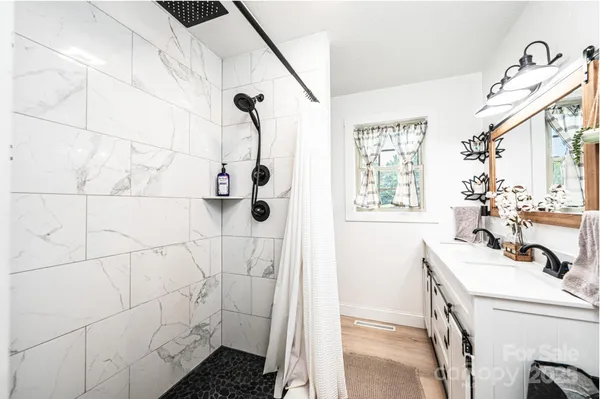 a bathroom with a sink mirror and shower