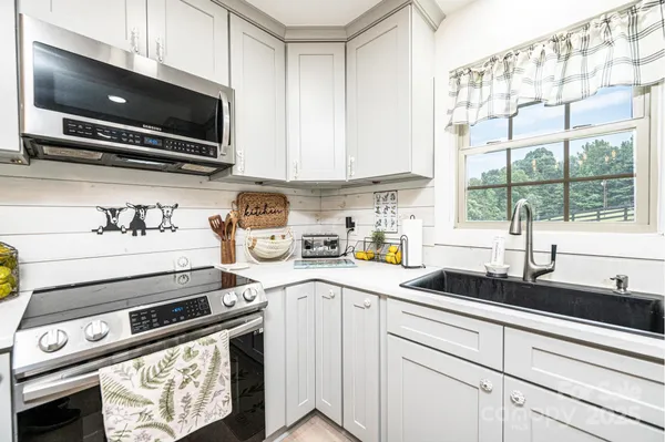 a kitchen with a sink a stove and cabinets