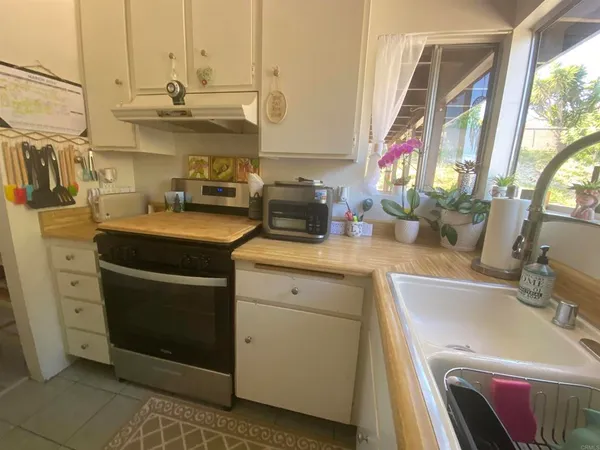 a kitchen with a sink and a stove next to a window
