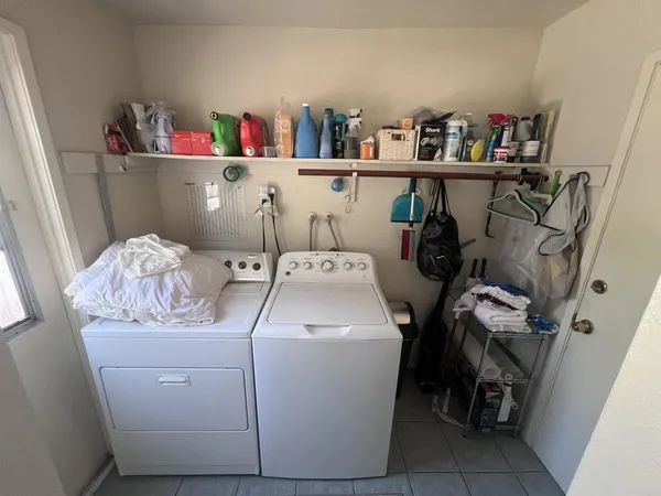 a utility room with dryer washer and shoe rack