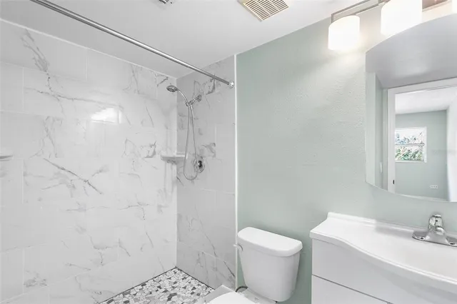 a bathroom with a shower a toilet and sink