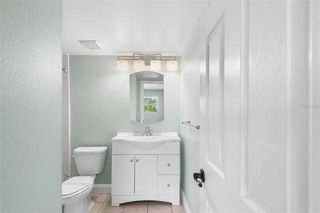 a bathroom with a toilet a sink and a mirror