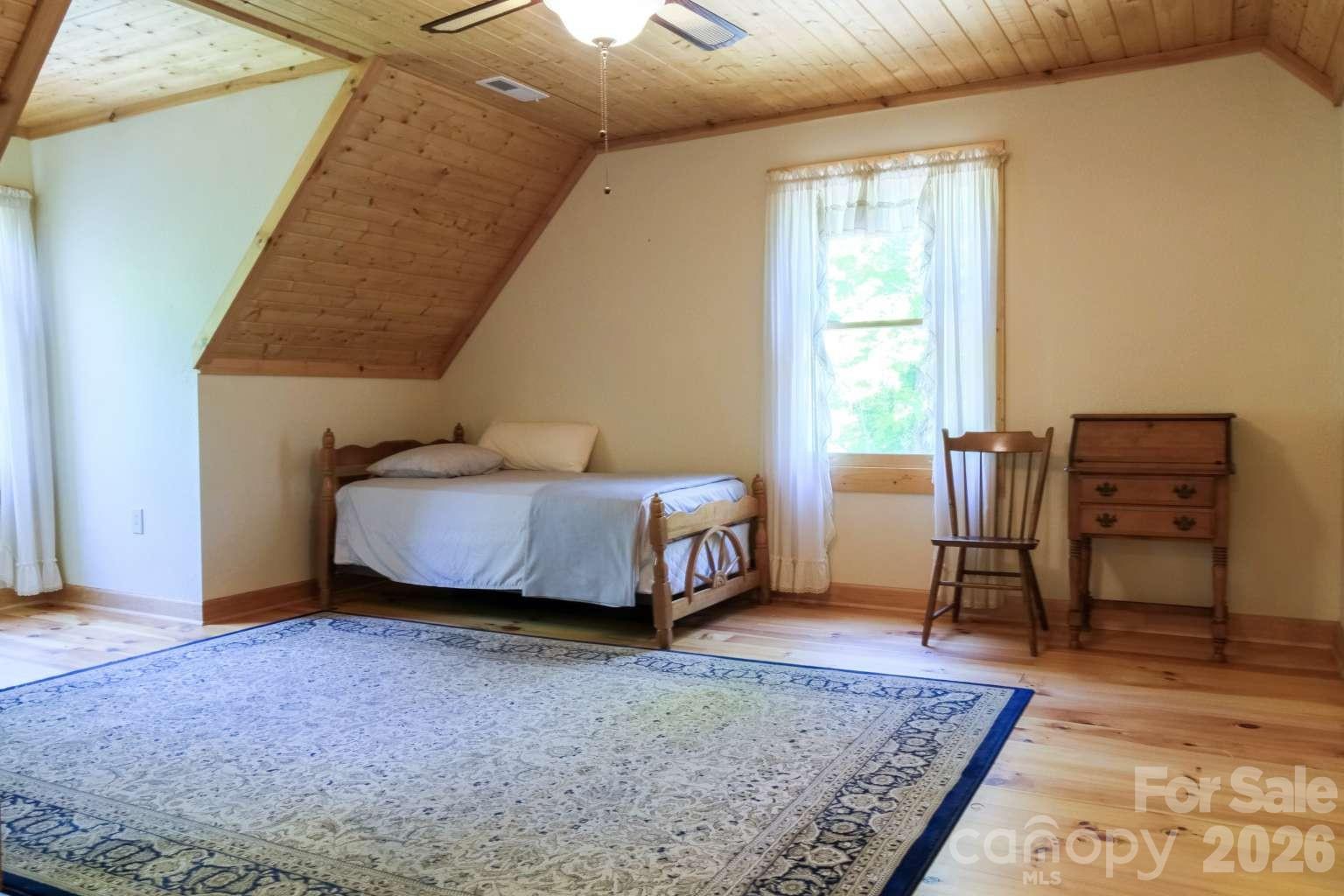 3815 Bat Cave Road Old Fort, NC 28762 - Photo 27 of 45 a bedroom with a bed and a table in it