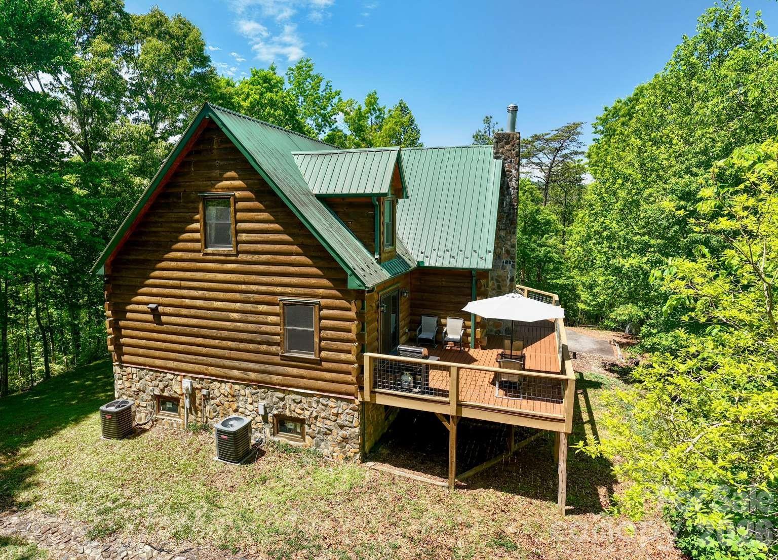3815 Bat Cave Road Old Fort, NC 28762 - Photo 3 of 45 a backyard of a house with table and chairs