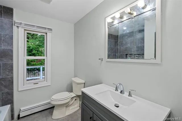 a bathroom with a sink vanity mirror and toilet