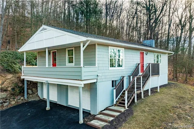 a view of a house with a wooden deck and furniture