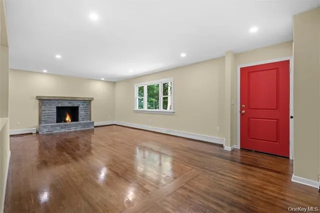 an empty room with windows and fireplace