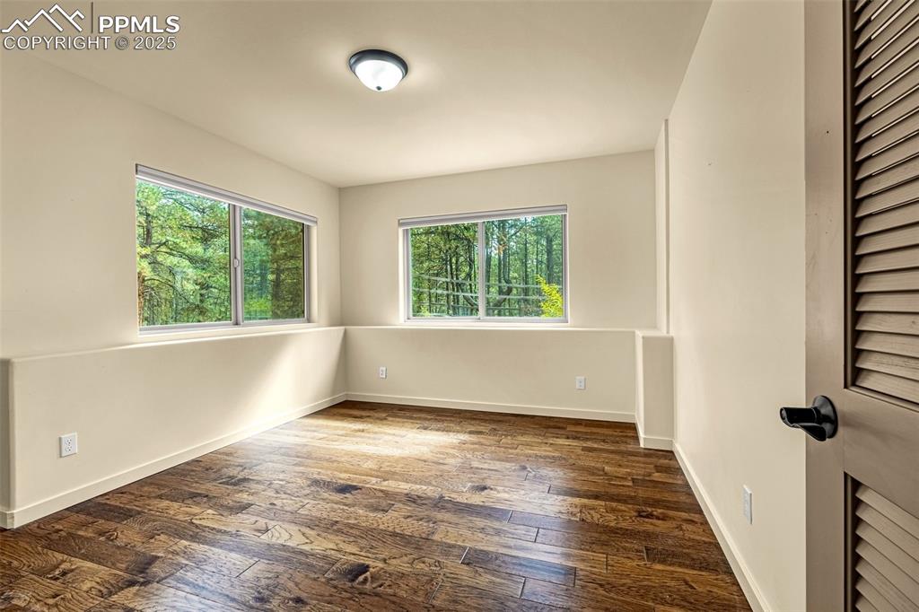 9890 Hardy Road Colorado Springs, CO 80908 - Photo 30 of 41 an empty room with wooden floor and windows
